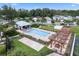 Community swimming pool with lounge chairs, a shaded pergola, and palm trees on a sunny day at 1324 Painted Bunting Ave, Oakland, FL 34787