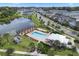 Community swimming pool is seen from above, featuring lounge chairs, pergola and nearby pond at 1324 Painted Bunting Ave, Oakland, FL 34787