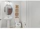 Charming powder room featuring a pedestal sink, decorative mirror, and patterned wallpaper at 1324 Painted Bunting Ave, Oakland, FL 34787