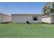 Exterior view of backyard showing house with lush green lawn and an air conditioner at 1461 Sothell St, The Villages, FL 32162