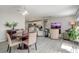 Open-concept living room and dining area with ceiling fan and wood-look laminate floors at 1461 Sothell St, The Villages, FL 32162