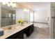 Bright bathroom featuring double sinks, soaking tub, and glass-enclosed shower at 1577 Mulligan Blvd, Davenport, FL 33896