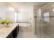 Bright bathroom featuring double sinks, soaking tub, and glass-enclosed shower at 1577 Mulligan Blvd, Davenport, FL 33896