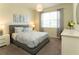 Sunlit bedroom with cozy bed, modern nightstands, and a window, creating a relaxing space at 1577 Mulligan Blvd, Davenport, FL 33896