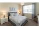 Bright bedroom features a comfortable bed, nightstands with lamps, and a large window offering natural light at 1577 Mulligan Blvd, Davenport, FL 33896