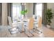 Bright dining room with white table, chairs, modern chandelier, and views of the outdoors at 1577 Mulligan Blvd, Davenport, FL 33896
