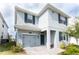 Two-story home with gray exterior, blue shutters, well-kept landscaping, and a one-car garage at 1577 Mulligan Blvd, Davenport, FL 33896
