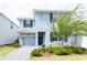 Two-story home with gray exterior, blue shutters, well-kept landscaping, and a one-car garage at 1577 Mulligan Blvd, Davenport, FL 33896