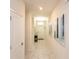 Hallway with white marble floors and white walls with modern art leading to the front door at 1577 Mulligan Blvd, Davenport, FL 33896