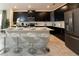 Modern kitchen with black cabinets, stainless steel appliances, and a white island with bar seating at 1577 Mulligan Blvd, Davenport, FL 33896