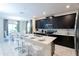 Open concept kitchen with breakfast bar that overlooks dining area with modern chandelier and large windows at 1577 Mulligan Blvd, Davenport, FL 33896