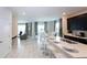 Open-concept kitchen with breakfast bar, stainless steel sink, and a view of the dining and living areas at 1577 Mulligan Blvd, Davenport, FL 33896