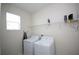 Functional laundry room with front load washer and dryer and wire rack shelving at 1577 Mulligan Blvd, Davenport, FL 33896