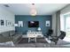 Cozy living room featuring a blue accent wall, comfortable seating, and modern decor at 1577 Mulligan Blvd, Davenport, FL 33896