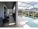 A covered patio with seating right next to the screened in pool at 1577 Mulligan Blvd, Davenport, FL 33896