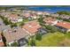 An aerial view of a community with tile roofs and a screened-in pool overlooking a lake at 16675 Otterchase Ln, Winter Garden, FL 34787