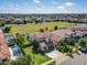 Expansive aerial view of a community with manicured lawns, red tile roofs, and a sparkling pool at 16675 Otterchase Ln, Winter Garden, FL 34787