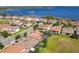 An aerial view of a residential area with tile roofs, screened-in pools and a lake in the background at 16675 Otterchase Ln, Winter Garden, FL 34787