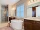 Beautiful bathroom featuring a soaking tub, walk-in shower, and dual vanities with a barn door accent at 16675 Otterchase Ln, Winter Garden, FL 34787