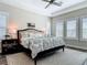Bright bedroom with a tray ceiling, dark wood floors, and large windows with plantation shutters at 16675 Otterchase Ln, Winter Garden, FL 34787