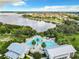 Stunning aerial view of a community pool and facilities next to a scenic lake, highlighting the community's amenities at 16675 Otterchase Ln, Winter Garden, FL 34787