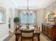 Elegant dining room with a tray ceiling, stone accent wall, and a chandelier over the wood dining table at 16675 Otterchase Ln, Winter Garden, FL 34787