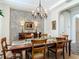 Elegant dining room with a tray ceiling, stone accent wall, and a chandelier over the wood dining table at 16675 Otterchase Ln, Winter Garden, FL 34787