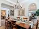 Elegant dining room with a tray ceiling, stone accent wall, and a chandelier over the wood dining table at 16675 Otterchase Ln, Winter Garden, FL 34787
