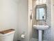 Stylish half-bathroom with patterned accent wall, pedestal sink, and modern fixtures at 16675 Otterchase Ln, Winter Garden, FL 34787