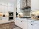 Bright kitchen features stainless appliances, granite counters, white cabinets, and stylish backsplash at 16675 Otterchase Ln, Winter Garden, FL 34787