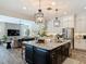 Open concept kitchen features stainless steel appliances, granite island, and easy access to living area at 16675 Otterchase Ln, Winter Garden, FL 34787