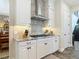 Bright kitchen with white cabinetry, granite countertops, and modern stainless steel range hood at 16675 Otterchase Ln, Winter Garden, FL 34787