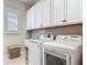 Laundry room with white front-loading washer and dryer, gray backsplash, and bright lighting at 16675 Otterchase Ln, Winter Garden, FL 34787