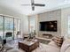 Comfortable living room with stone accent wall, ceiling fan, and sliding doors to the outdoor patio at 16675 Otterchase Ln, Winter Garden, FL 34787