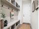 Organized mudroom with built-in bench, storage shelves, hooks, and a door at 16675 Otterchase Ln, Winter Garden, FL 34787