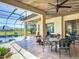 Covered patio with a lounge and dining area overlooking the pool and backyard, complete with stylish decor at 16675 Otterchase Ln, Winter Garden, FL 34787