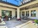 Charming covered patio featuring a ceiling fan, elegant dining set, and decorative potted plants at 16675 Otterchase Ln, Winter Garden, FL 34787