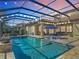 Inviting screened-in pool with lounge chairs and string lights, perfect for relaxation and entertaining at 16675 Otterchase Ln, Winter Garden, FL 34787