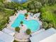 Aerial view of the community pool featuring sun loungers, tables, and lush landscaping at 16675 Otterchase Ln, Winter Garden, FL 34787