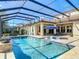 Outdoor pool area with patio, tanning chairs, blue umbrella, and view of the manicured lawn at 16675 Otterchase Ln, Winter Garden, FL 34787