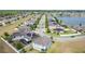 Aerial view showcases houses in neighborhood, along with a beautiful lake at 1671 Thetford Cir, Orlando, FL 32824