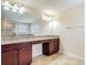 Bathroom featuring double vanities with granite countertops and wood cabinets at 1671 Thetford Cir, Orlando, FL 32824
