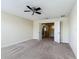 Spacious carpeted bedroom with ceiling fan and doors leading to hallway at 1671 Thetford Cir, Orlando, FL 32824