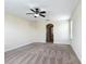 Carpeted bedroom with ceiling fan, natural light, and an arched doorway to the hallway at 1671 Thetford Cir, Orlando, FL 32824