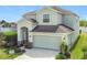 Charming two-story home featuring an attached two-car garage and beautifully landscaped front yard at 1671 Thetford Cir, Orlando, FL 32824