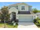 Charming two-story home features a well-manicured lawn, an attached two-car garage, and stone accents at 1671 Thetford Cir, Orlando, FL 32824