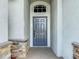 The home's entryway features stone accents and a gray front door with transom window at 1671 Thetford Cir, Orlando, FL 32824