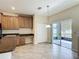 Kitchen with desk, tile floors, wood cabinets, and sliding glass doors to patio at 1671 Thetford Cir, Orlando, FL 32824