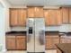 Stainless steel refrigerator set among granite countertops and wood cabinets at 1671 Thetford Cir, Orlando, FL 32824