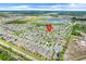 Expansive aerial view of a neighborhood featuring numerous homes, a scenic lake, and convenient road access at 1706 Lake Sims Pkwy, Ocoee, FL 34761